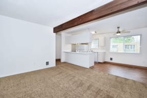 the living room and kitchen of an empty house with a carpet
