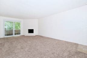 an empty living room with a fireplace and a window