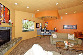 A living room with a fireplace and a dining table.