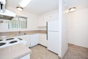 a white kitchen with white appliances and white cabinets