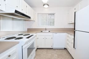 a white kitchen with white appliances and white cabinets