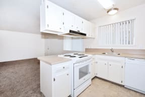 a kitchen with white cabinets and a stove and a sink
