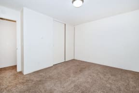 an empty room with white walls and carpet
