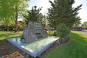 A fountain in front of a sign that says Stone Creek.