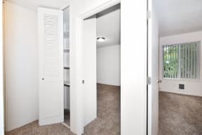 an empty room with a closet and a window