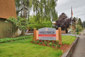 a sign for metro manor apartments in front of a street