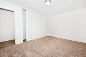 an empty room with white closets and carpeting