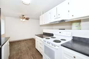 an empty kitchen with white appliances and white cabinets