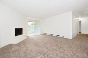 an empty living room with a fireplace and a window