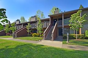A row of houses with green lawns in front.