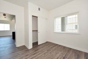 a bedroom with hardwood floors and white walls