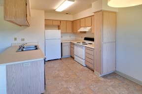 a kitchen with white appliances and wooden cabinets