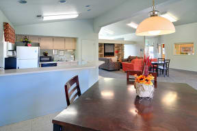 a kitchen and living room with a dining table and chairs