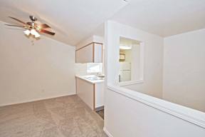 a renovated living room and kitchen with a ceiling fan
