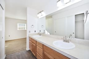 Twin Oaks Apartments a bathroom with two sinks and a large mirror