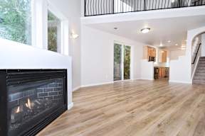A modern living room with a fireplace and wooden floors.