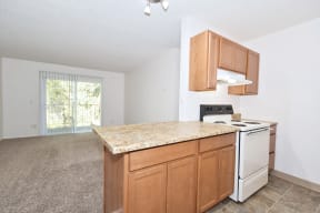 a kitchen with an island and a living room in the background