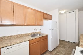 a kitchen with a white refrigerator freezer next to a dishwasher