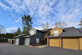 a house with a garage and a cloudy blue sky