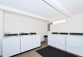 a laundry room with white washers and dryers