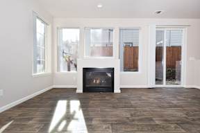 A room with a fireplace and wood flooring.