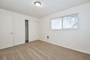 a bedroom with white walls and carpet