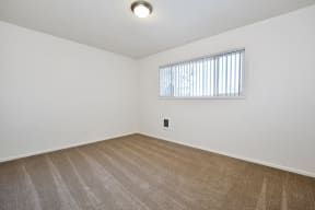 a bedroom with white walls and a large window