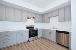 a kitchen with gray cabinets and white countertops