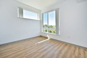 a bedroom with hardwood floors and white walls