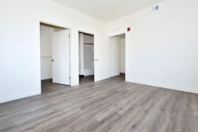 a bedroom with hardwood floors and white walls