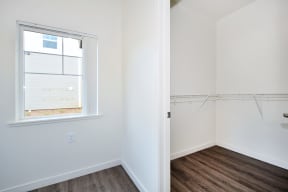 a bedroom with a large window and white walls