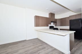 a kitchen with a white counter top and a black refrigerator