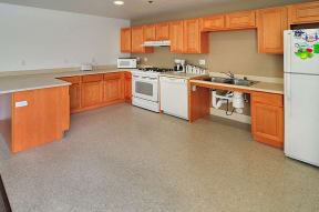 a large kitchen with wooden cabinets and white appliances
