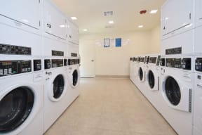 a laundry room with white washers and dryers
