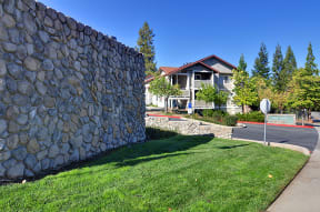 a stone retaining wall with a house in the background