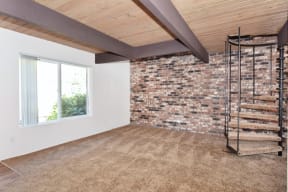 a room with carpeted floors and a brick wall