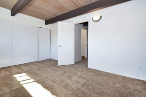 a bedroom with white walls and carpet