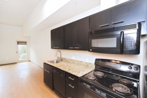 a kitchen with black cabinets and a granite counter top