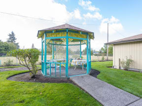 a gazebo with tables and chairs in a yard