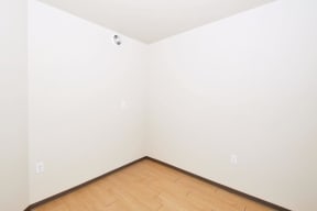 an empty room with white walls and a wooden floor