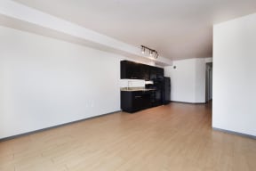 an empty living room with a hardwood floor and white walls