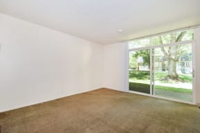 a bedroom with a large window and white walls