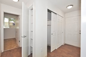 a bedroom with two closets and a bathroom in the background