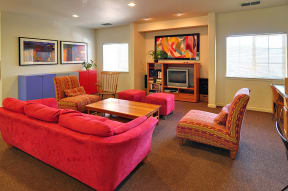 a living room with a red couch and two chairs