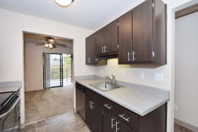 a kitchen with dark cabinets and a ceiling fan