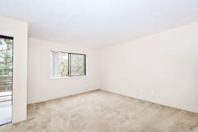 a bedroom with white walls and a window