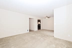 an empty living room with a ceiling fan