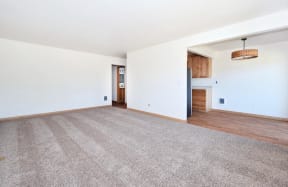 a living room with white walls and hardwood floors
