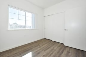 a bedroom with a large window and white walls