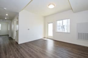 a bedroom with hardwood floors and white walls